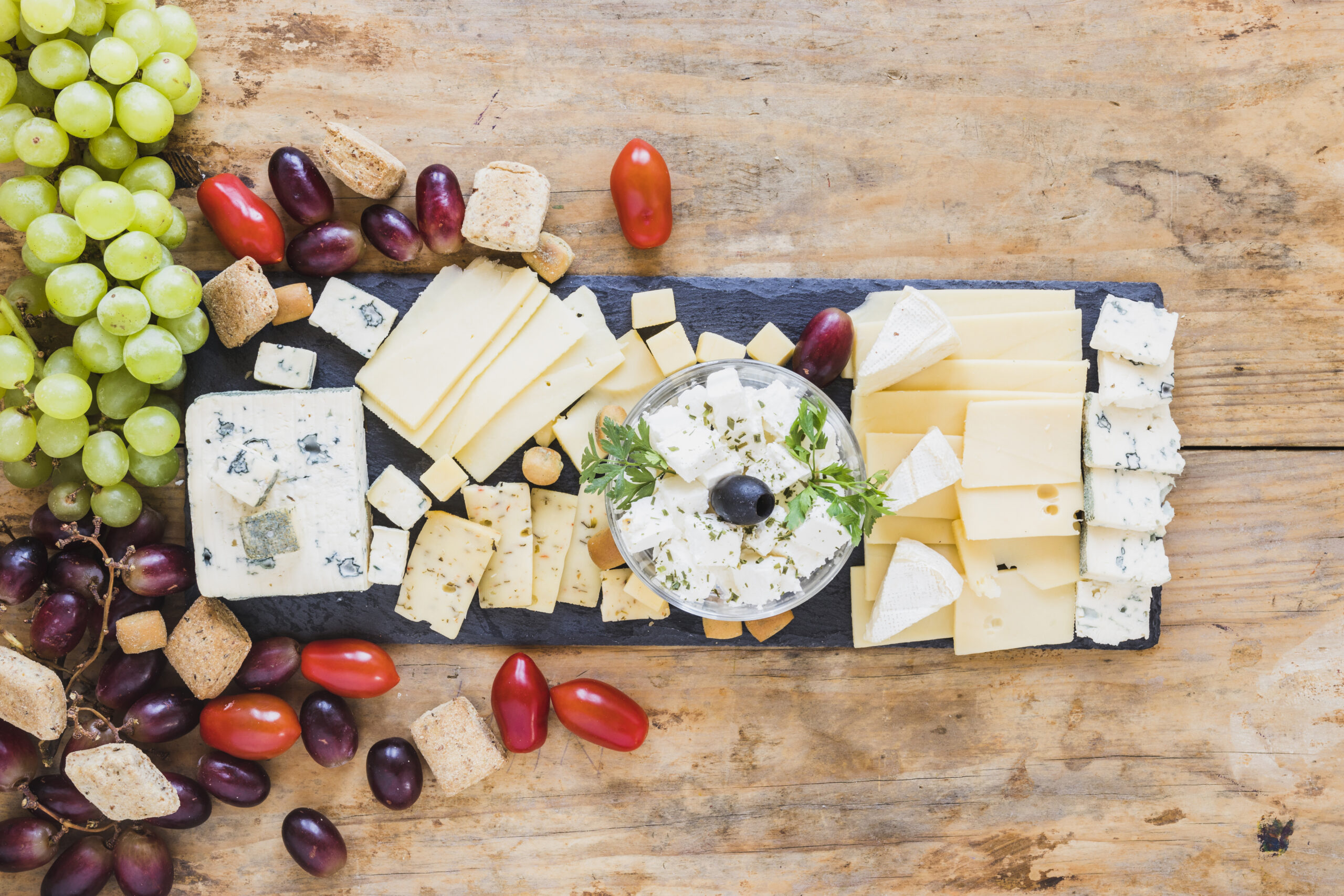 Cheese board featuring cheese, grapes, and assorted fruit